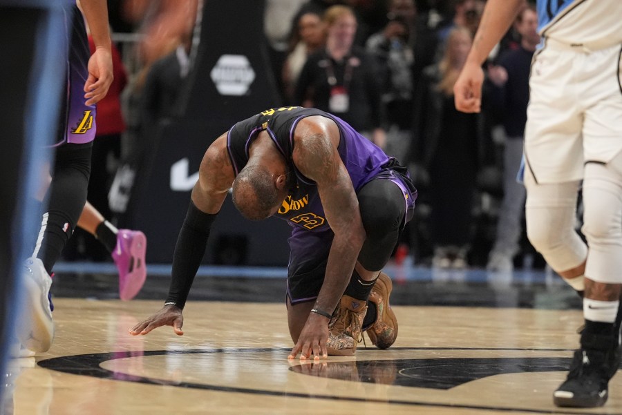 Los Angeles Lakers forward LeBron James (23) kneels on the court in the second half of an NBA basketball game against the Atlanta Hawks, Friday, Dec. 6, 2024, in Atlanta. (AP Photo/Brynn Anderson)