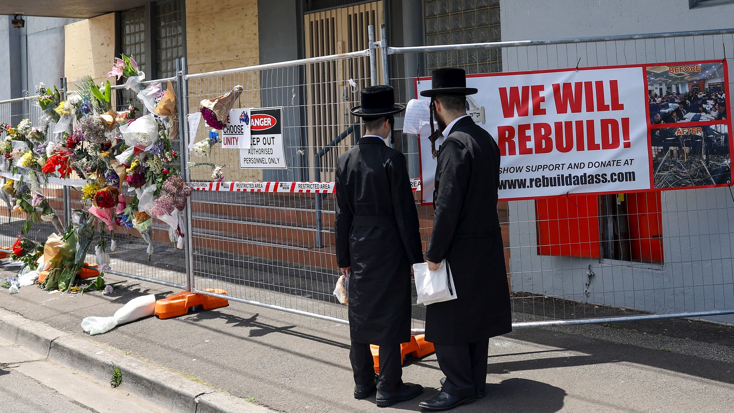People gather outside the fire damaged Adass Israel Synagogue in Melbourne, Monday, Dec. 9, 2024. (Con Chronis/AAP Image via AP)