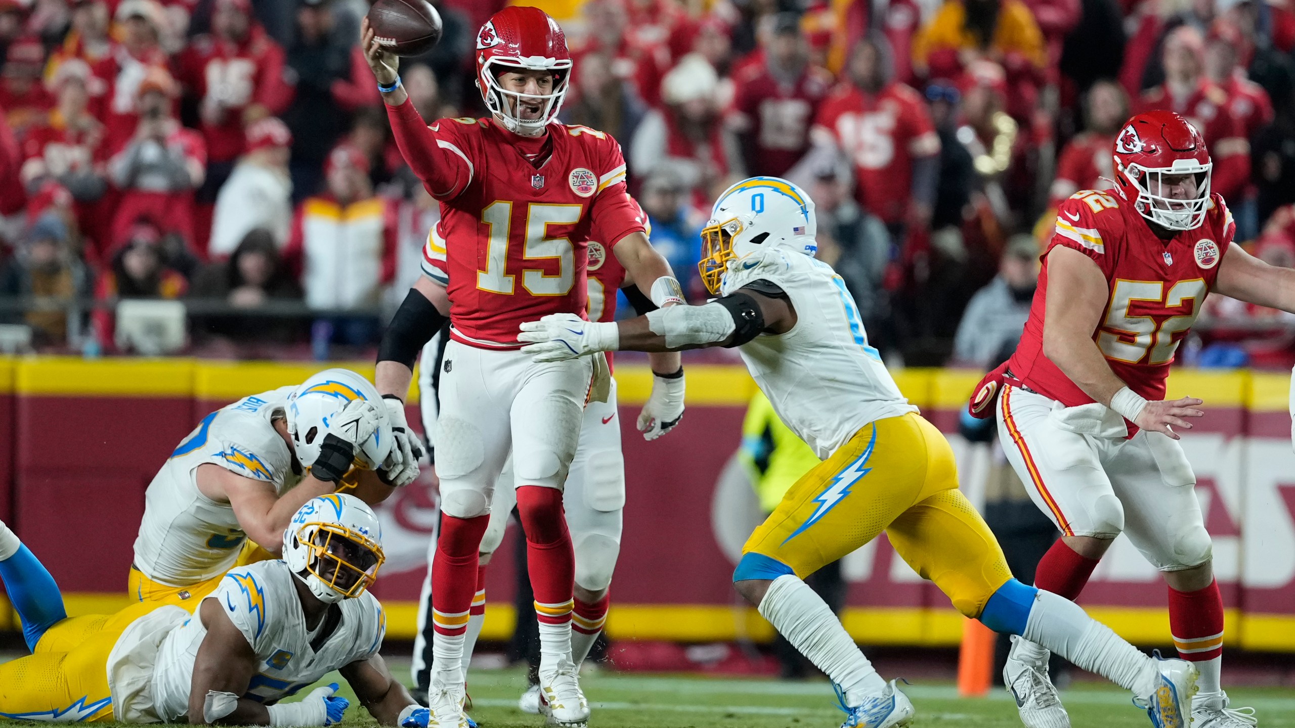 Kansas City Chiefs quarterback Patrick Mahomes (15) throws under pressure from Los Angeles Chargers linebacker Daiyan Henley (0) during the second half of an NFL football game Sunday, Dec. 8, 2024, in Kansas City, Mo. (AP Photo/Ed Zurga)