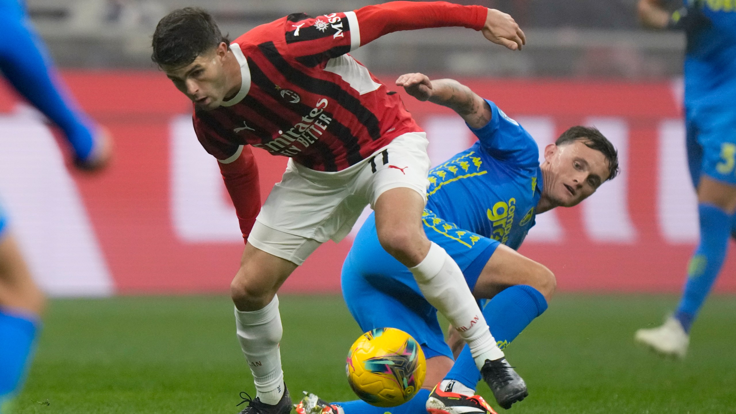 AC Milan's Christian Pulisic is challenged by Empoli's Liam Henderson, right, during the Italian Serie A soccer match between AC Milan and Empoli, at the Milan San Siro stadium, Italy, Saturday, Nov. 30, 2024. (AP Photo/Luca Bruno)