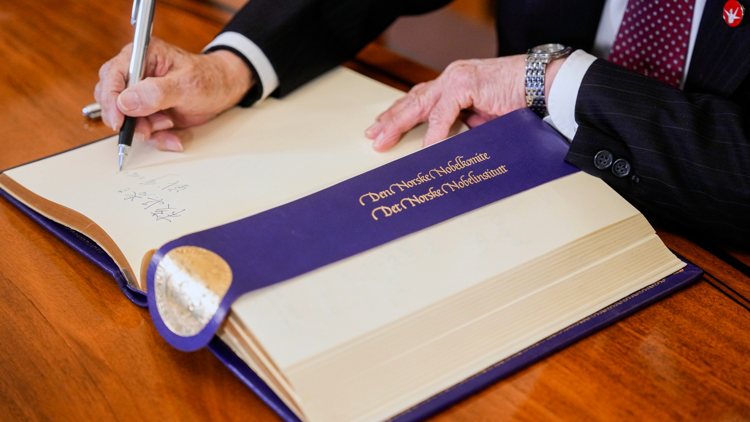 Representative of this year's Nobel Peace Prize winner Nihon Hidankyo, or the Japan Confederation of A- and H-Bomb Sufferers Organizations, Terumi Tanaka signs the guest book ahead of the Nobel Peace Prize ceremony, at the Nobel Institute in Oslo, on Monday, Dec. 9, 2024. (Javad Parsa/NTB Scanpix via AP)