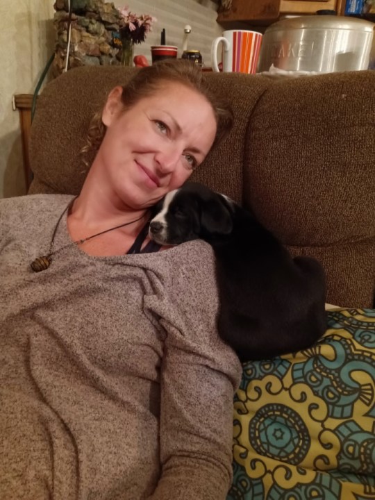 A smiling woman and a puppy